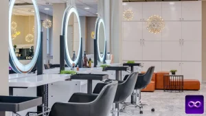 référencement coiffeur : fauteuils noirs et miroirs ronds éclairés dans un salon de coiffure vide